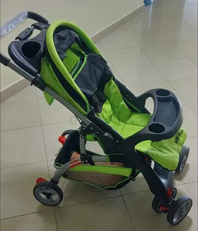 Lightweight green baby stroller with tray and storage basket