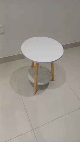 Small round side table with wooden legs and lower shelf - white
