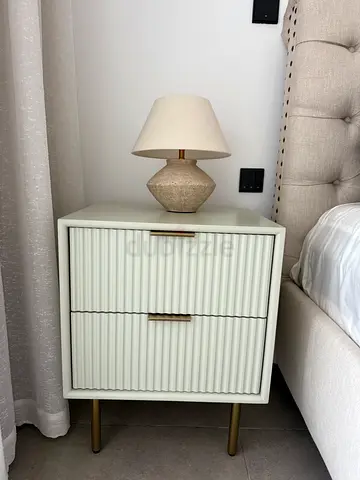 Modern bedside nightstand with ribbed doors and brass legs