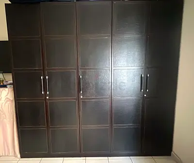 Dark wood 5-door wardrobe with ample storage - good condition. Leather finish.