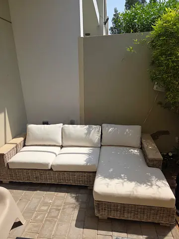 Outdoor rattan corner sofa with cream cushions
