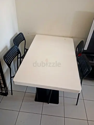 White Small dining table with 4 black plastic chairs - good condition