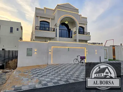 Villa for sale in Al Helio 2, Ajman. 5 master bedrooms, majlis, living room with kitchen, maid's room. 3 floors: ground, first, and roof.