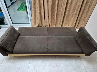 Brown upholstered daybed/sofa bed with pillows in good condition