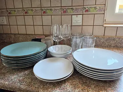 Mixed set of plates, bowls and glassware — used dining set