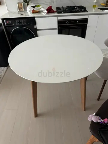 Round white dining table with wooden legs - compact