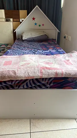 Single white wooden kids bed with headboard shelf. Dismantled now