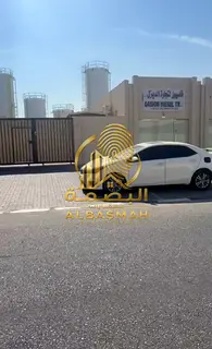 Enclosed yard for sale in Sajaa Industrial Area, Sharjah, featuring two shops at the front; area: 14