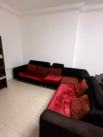 L-shaped sectional 6 seater sofa in black with red cushions - good condition