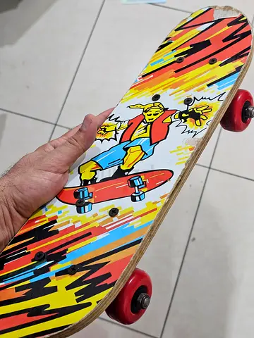 Used colorful single-kick skateboard with red wheels