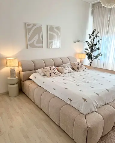 Large upholstered platform bed with tufted headboard in beige