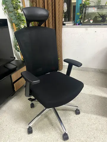 Ergonomic black office chair with headrest and adjustable armrests