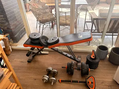 Adjustable weight bench with dumbbells and weight plates - used