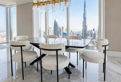 Modern black dining table with 6 boucle chairs - Dubai skyline view