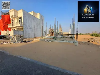 Residential plot for sale in a prime location in Al Helio 2, Ajman. It is ready for construction, with concrete and columns already in place. The pric