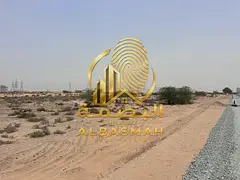 Corner commercial land for sale in Sharjah, Al Malha area, Al Ruwaidat suburb, opposite the school.