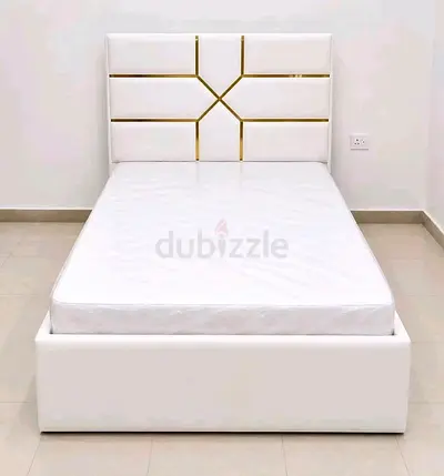 Single white upholstered bed with geometric gold-accent headboard