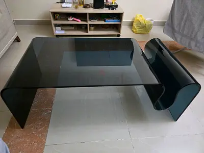 Curved smoked glass coffee table with integrated magazine rack