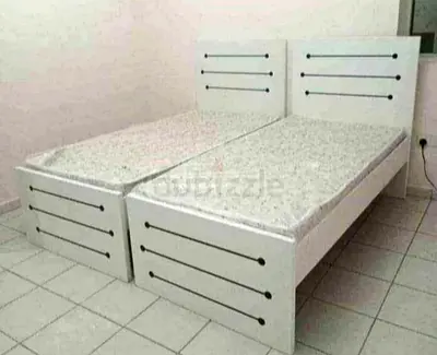 single white wooden beds with mattresses