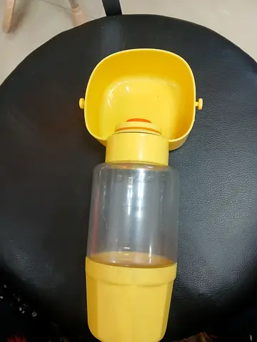 Portable yellow pet water bottle with attached bowl — used
