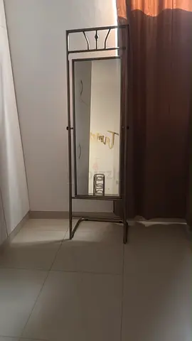 Free-standing full-length metal framed mirror with small shelf