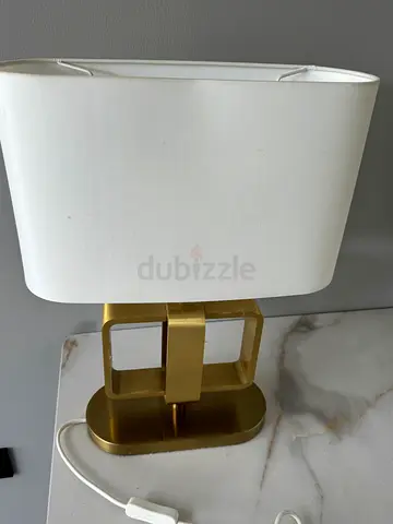 Compact bedside table lamp with white shade and gold brass base