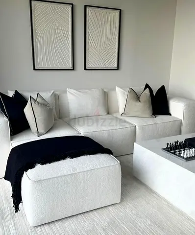 Modern white L-shaped sectional sofa with ottoman