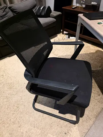 Black mesh office visitor chair with armrests