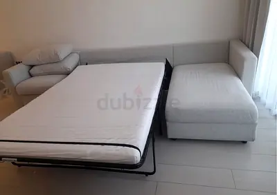 Light beige fabric L-shaped sofa bed with pull-out bed - good condition
