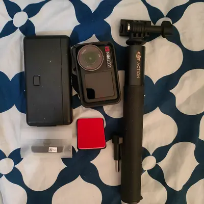 DJI Action 5 camera with accessories (battery case, grip, mounts)