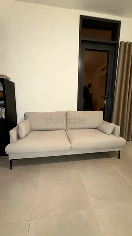 Light beige 2-seater sofa with slim legs – good condition
