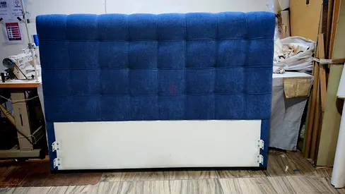 Blue upholstered queen headboard with tufted design
