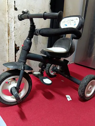 Used black toddler tricycle with safety bar and bell