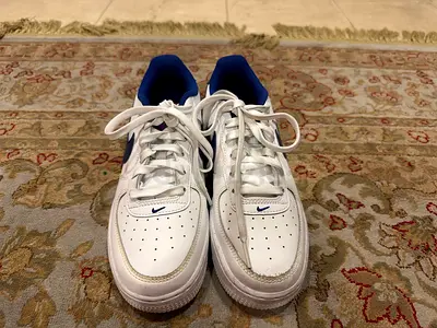 Nike Air Force 1 Low White & Blue — Classic white Air Force 1s with blue Nike Swoosh and detailing.