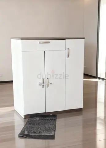 Compact white storage cabinet with drawer and side cupboard