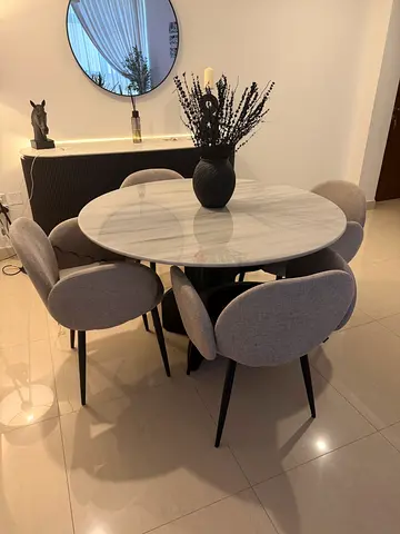 Round dining table with 4 grey upholstered chairs