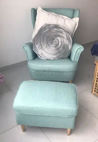 Light blue upholstered armchair with matching ottoman. Needs deep cleaning.