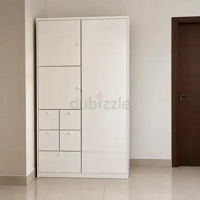 White freestanding wardrobe with multiple drawers and doors