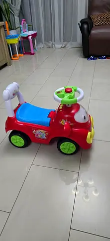 Red ride-on toy car for toddlers with steering wheel and push handle and music