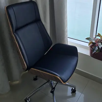 Modern ergonomic office chair with wooden shell and black leatherette upholstery