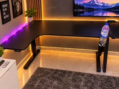 L-shaped black gaming/office desk with cable grommets and sturdy metal legs