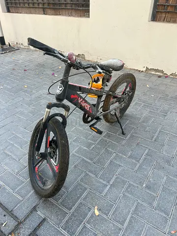 Child's black and red BMX-style bike with training wheels — used