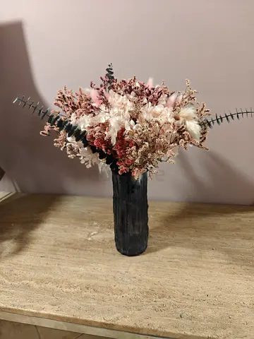 Dried flower arrangement in black ceramic vase