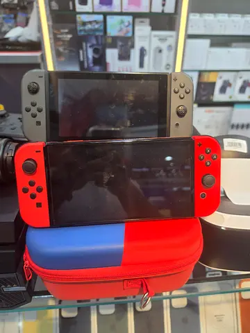 Two Nintendo Switch consoles with Joy-Cons and carrying case - used