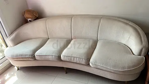 Light beige 4-seater curved sofa with cushions — good condition