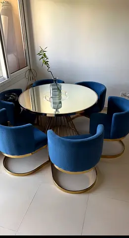 Round glass dining table with 6 blue velvet chairs