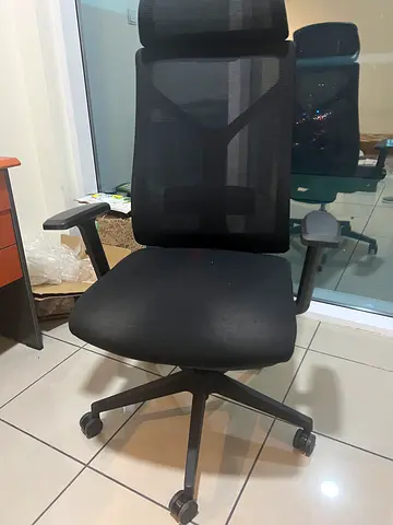 Black ergonomic office chair with headrest and adjustable armrests