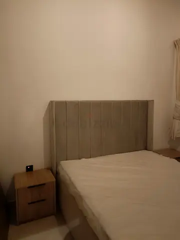 Upholstered king-size bed frame with padded headboard