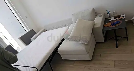 Light beige L-shaped sofa bed with pull-out bed - good condition