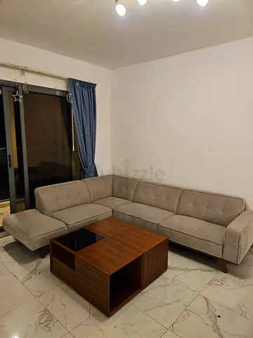 Light grey L-shaped sectional sofa with wooden coffee table